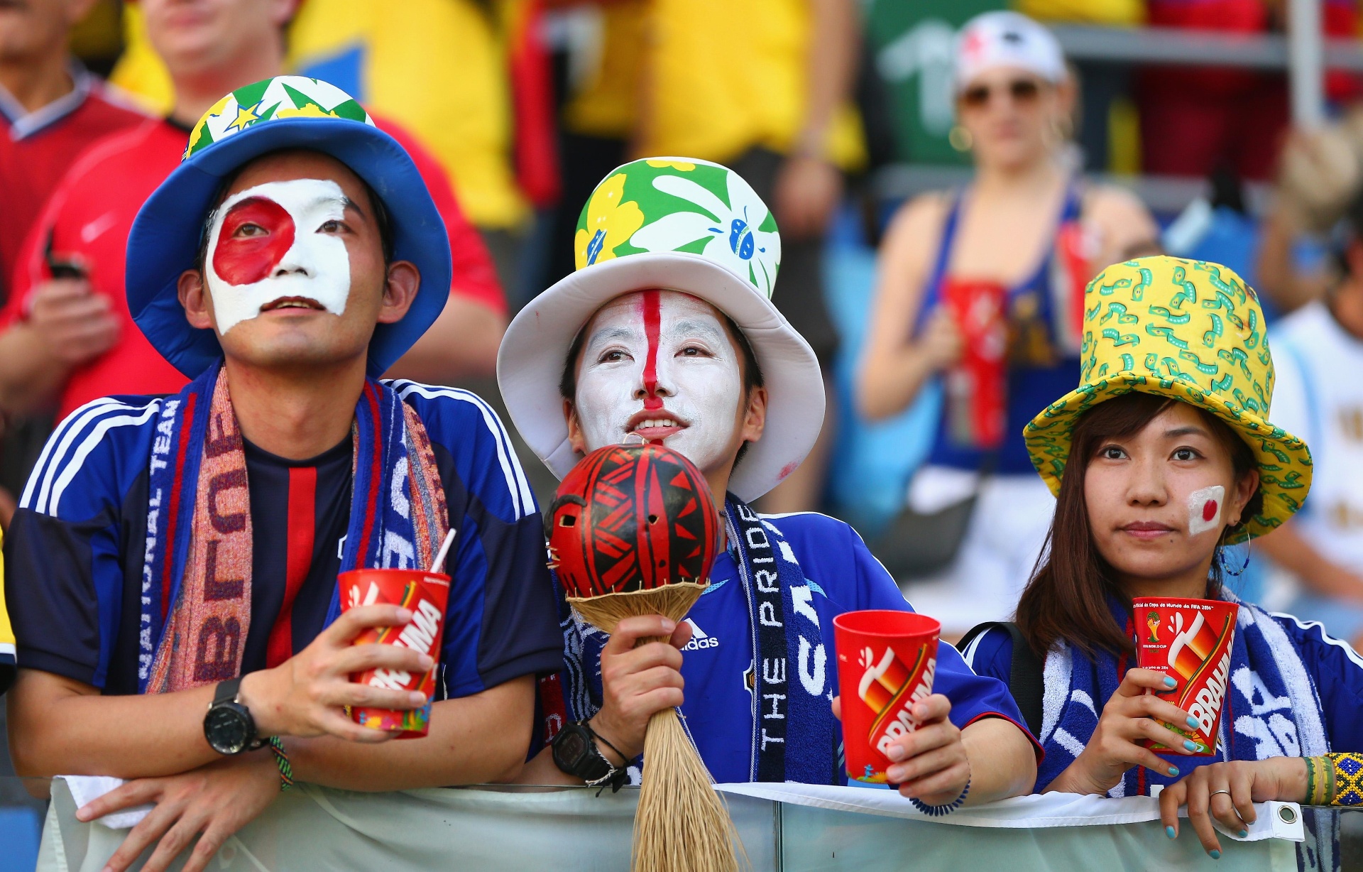 Japan supporters with face paint, bucket hats and scarves in the stands