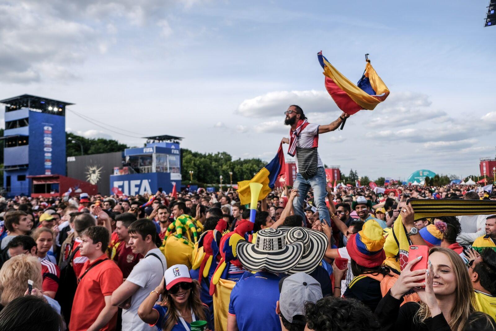Massive World Cup fan zone with supporters from multiple countries waving flags